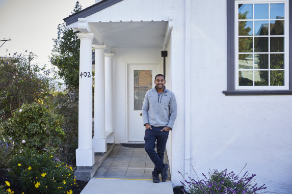 Man posing in front of home