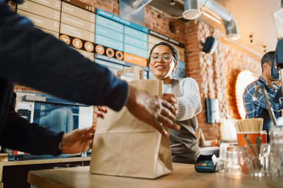 barista with a paper bag