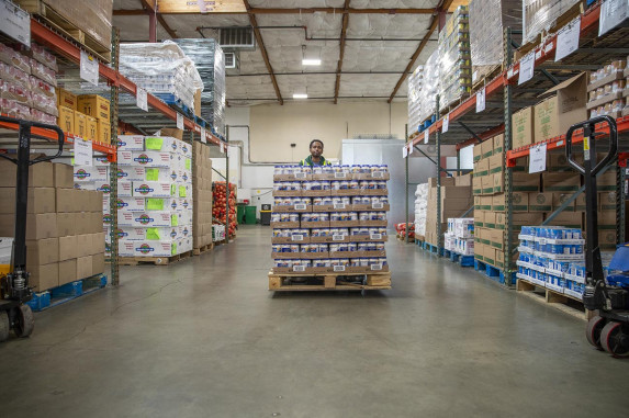 Man moving pallet of packaged food.