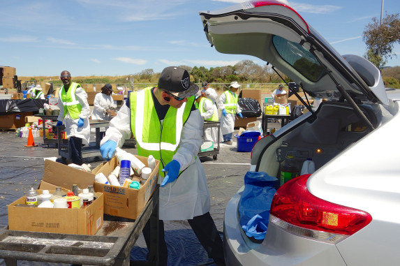 Technician unloading HHW items from car trunk