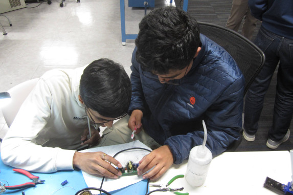 Two people fixing an electronic