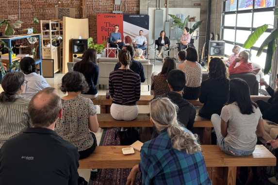Room of people sitting facing four presenters