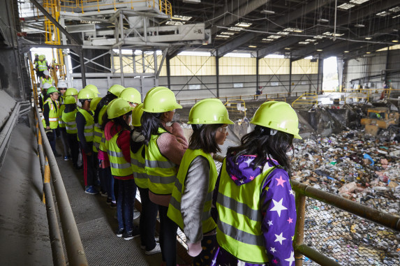  Students walking on catwalk in pit looking at waste