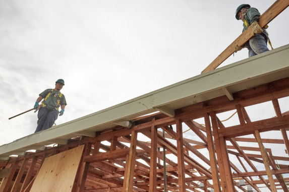 Two construction men on wooden structure 