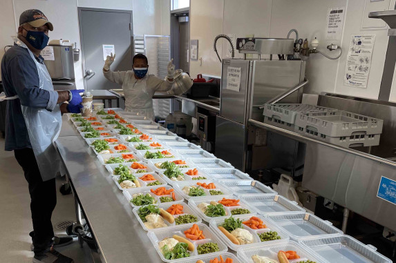 food containers being filled in a commercial kitchen