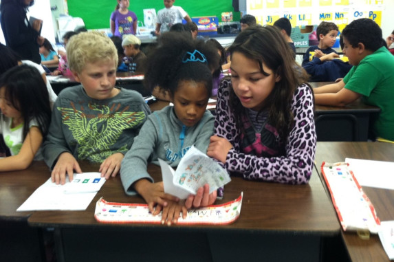 Students reading to a younger buddy student.