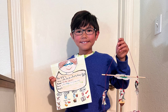 student holding up their contest entry