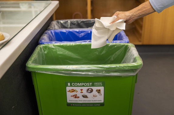 tossing paper towel into green bin in 3-bin station