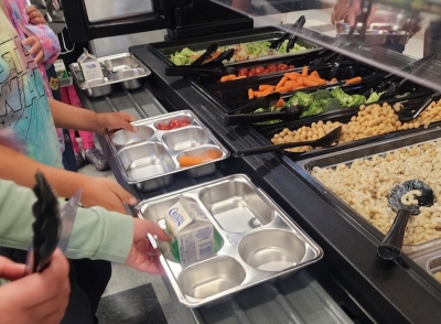 Students with reusable lunch trays serve themselves from the salad bar.